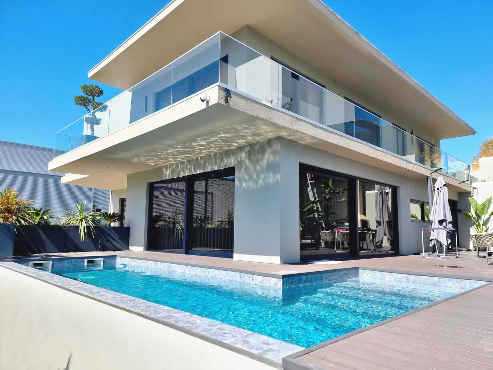 Moradia moderna com piscina e grandes vãos envidraçados